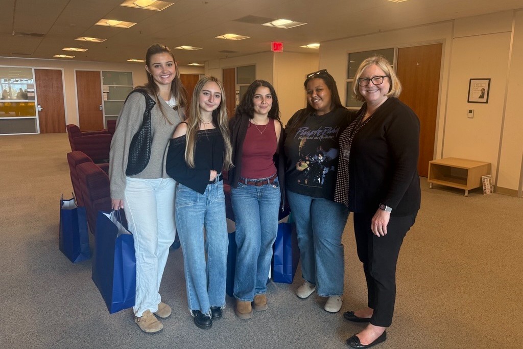 Students with Dr. Margarete Feinstein smiling for a photo